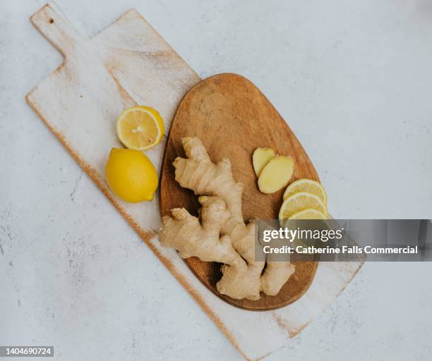 top down image of whole ginger and lemons on two wooden chopping boards - ginger plant imagens e fotografias de stock