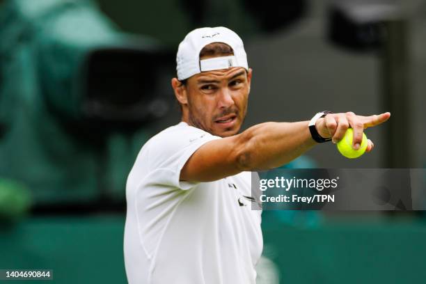 Rafael Nadal of Spain practices on centre court at the AELTC with coaches Francisco Roig and Marc Lopez in a historic first time ever use of centre...