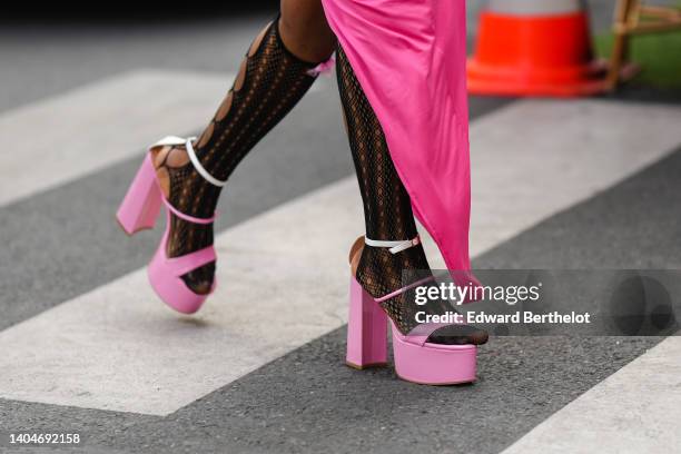 Guest wears a neon pink square-neck / tank-top / long asymmetric dress, black cut-out pattern high socks, pink shiny leather strappy / block heels...