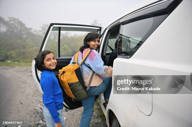 mother and daughter getting inside the car while travelling - northeast india stock pictures, royalty-free photos & images