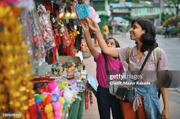 mother and daughter browsing souvenirs at street market - street market stock pictures, royalty-free photos & images