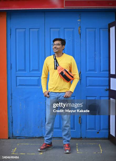 portrait of a man traveller standing in front of a blue coloured door - northeast india stock pictures, royalty-free photos & images