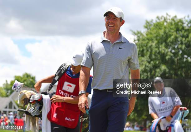 Rory McIlroy of Northern Ireland smiles as he finishes his round on the ninth green during the first round of Travelers Championship at TPC River...