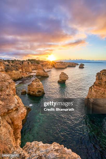 sunrise at praia da marinha's rocky cliffs along the famous algarve coast in southern portugal, europe - distrito de faro portugal imagens e fotografias de stock