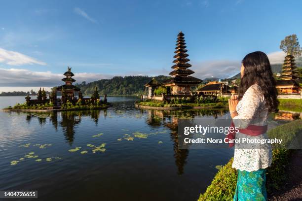 balinese woman praying at pura ulun danu bratan lake beratan bali indonesia - bedugal stock pictures, royalty-free photos & images