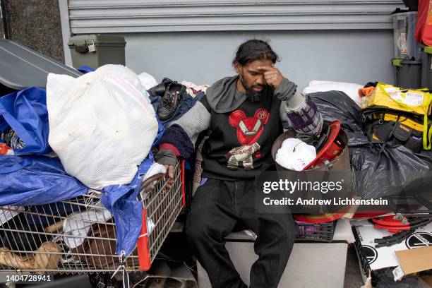 Homeless man reacts as he is forced to dismantle their possessions by the New York City Department of Sanitation and police officers as part of a...