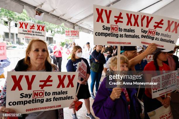 Demonstrators listen to the speaking program during an "Our Bodies, Our Sports" rally for the 50th anniversary of Title IX at Freedom Plaza on June...