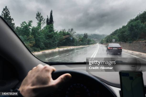 view through the windshield on traffic on a wet highway in the rain - perspective road stockfoto's en -beelden