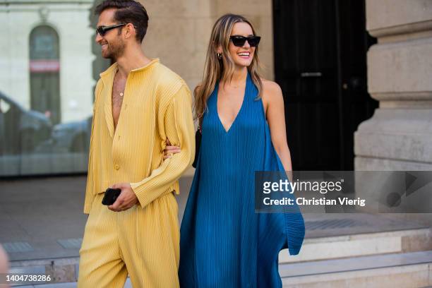 Couple seen wearing blue dress, yellow shirt, pants, sandals outside Issey Miyake during Paris Fashion Week - Menswear Spring/Summer 2023 on June 23,...
