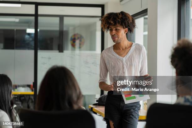 gay office mates are gathered discussing work issues - lesbian stock pictures, royalty-free photos & images