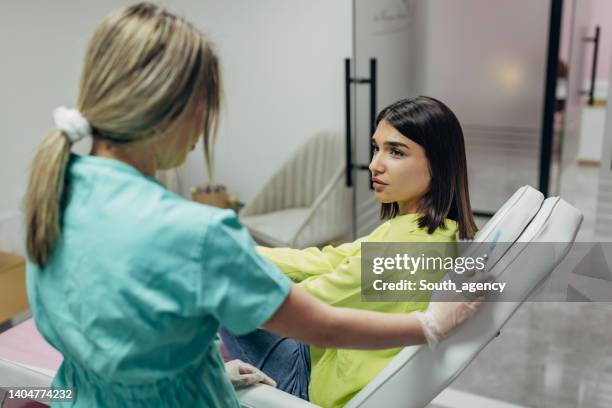 women at the beauty clinic - dermatologists talking to each other patient stock pictures, royalty-free photos & images