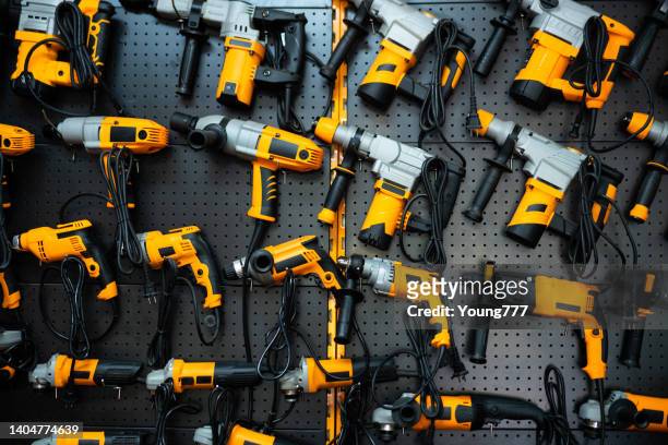many electric drills on the shelf - elektrisch gereedschap stockfoto's en -beelden