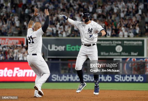 Aaron Judge of the New York Yankees celebrates his ninth inning game winning base hit against the Houston Astros with teammate Aaron Hicks at Yankee...