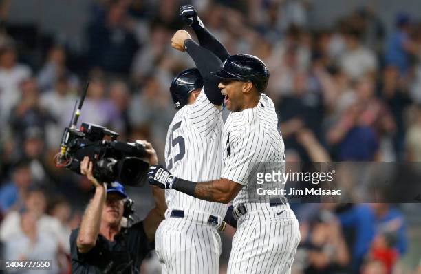 Aaron Hicks of the New York Yankees celebrates his ninth inning game tying three run home run against the Houston Astros with teammate Gleyber Torres...