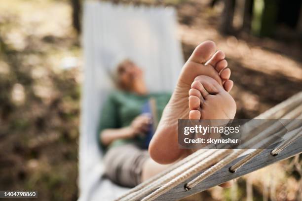 barefoot woman relaxing in hammock. - old lady feet 個照片及圖片檔