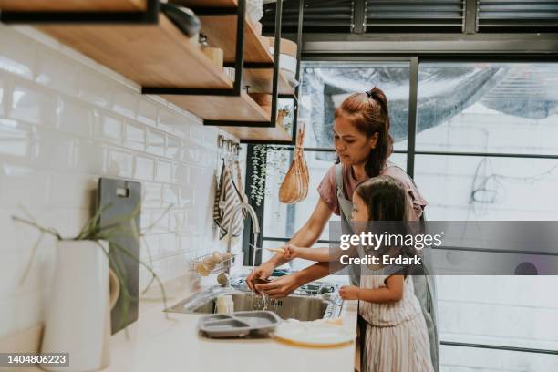 good girl helping mom doing housework. - water conservation stock pictures, royalty-free photos & images