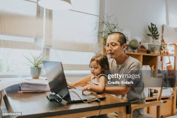 kleinkind mädchen genießt es, die arbeit ihres vaters auf dem laptop-bildschirm zu sehen. - teilzeitarbeiter stock-fotos und bilder