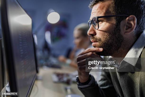 thoughtful male programmer reading codes on a pc in the office. - staring at screen stock pictures, royalty-free photos & images