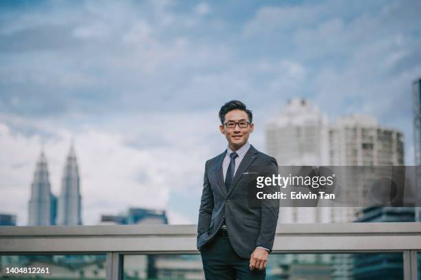 portrait asian chinese successful businessman looking at camera smiling with cityscape background - front view bildbanksfoton och bilder