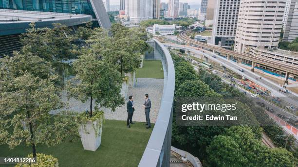 direkt über 2 geschäftsleuten, die sich auf dem dachgarten vor dem bürogebäude unterhalten - roof garden stock-fotos und bilder