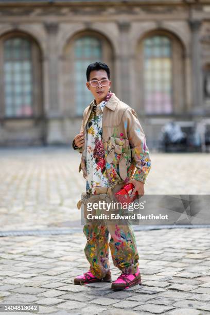 Guest wears beige sunglasses from Louis Vuitton, a white with multicolored print pattern oversized shirt, a beige with embroidered flower print...