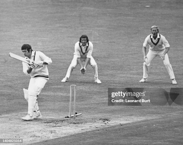 Surrey County Cricket Club slip fielders Graham Roope and Stewart Storey look on from behind the stumps as Barrie Leadbeater, right handed batter for...