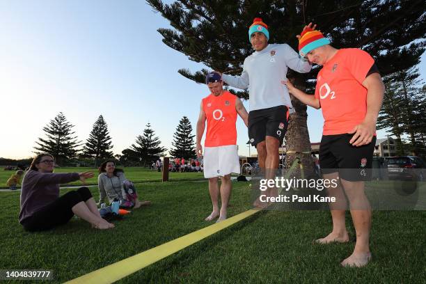 Tom Curry and Henry Arundell assist Will Joseph while slack lining during an England Rugby Squad beach recovery session at South Beach on June 24,...