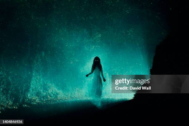 a supernatural concept of a spooky ghost woman, haunting a country road on a foggy winters night. with a grunge, vintage edit. - ghost stock pictures, royalty-free photos & images