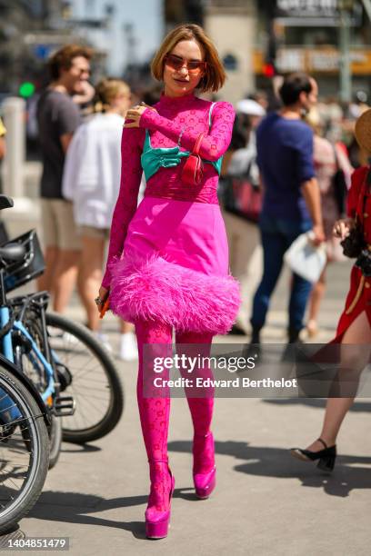 Guest wears orange sunglasses, silver earrings YSL pendant from Yves Saint Laurent, a neon pink with embroidered red pattern high neck / long sleeves...