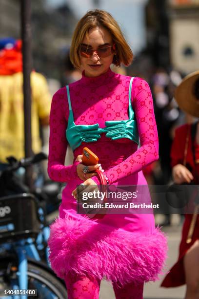 Guest wears orange sunglasses, silver earrings YSL pendant from Yves Saint Laurent, a neon pink with embroidered red pattern high neck / long sleeves...