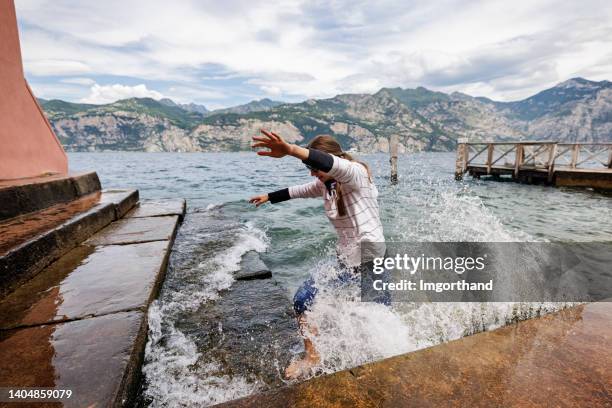 teenage girl enojoying walking in lake garda in malcesine old port - bad luck 個照片及圖片檔