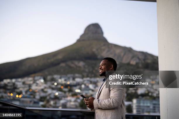 businessman on balcony looking up to view - cape town buildings stock pictures, royalty-free photos & images