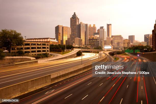 high angle view of light trails on road amidst buildings in city,atlanta,georgia - atlanta skyline car stock pictures, royalty-free photos & images