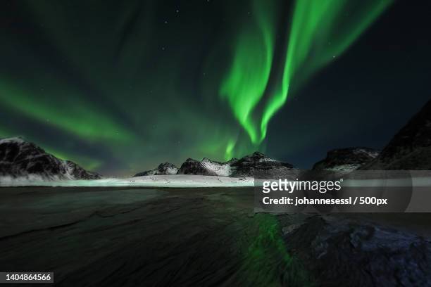 scenic view of aurora borealis over lake against sky at night,ramberg,nordland,norway - aurora borealis stock pictures, royalty-free photos & images