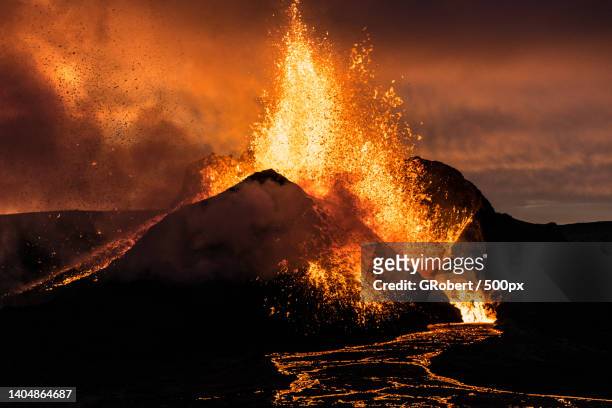 scenic view of volcanic mountain against sky - eruption stock-fotos und bilder