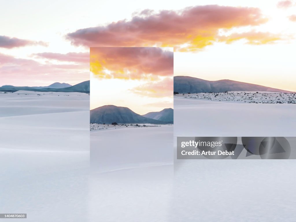 Mirror reflecting desert dunes with dramatic sunset sky in the Canary Islands.