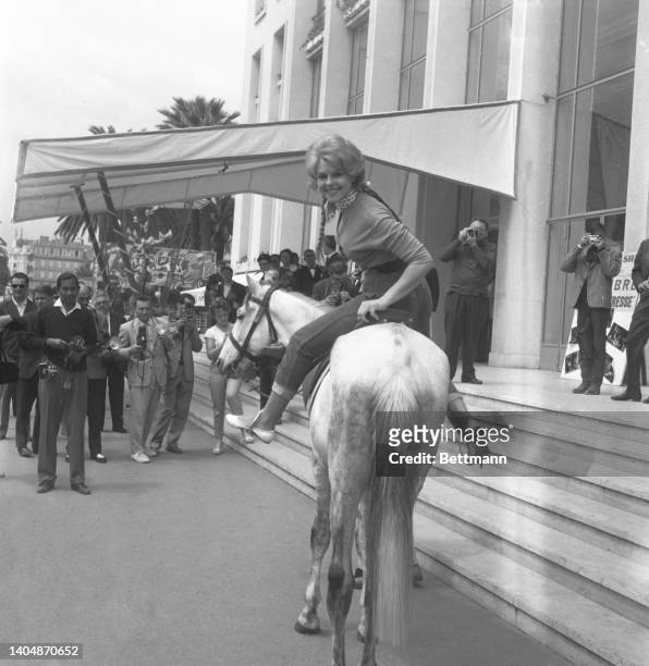 French actor Francoise Deldick on a horse in front of the Carlton Hotel in Cannes. She is attending the Cannes Film Festival.