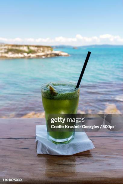 close-up of drink on table against sea,lozenets,bulgaria - krasimir georgiev stock-fotos und bilder