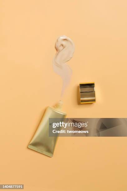 flat lay cosmetic liquid  foundation still life on cream coloured background. - foundation make up stock-fotos und bilder