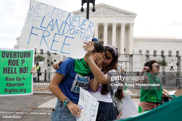 Abortion-rights activists Carrie McDonald and Soraya Bata react to the Dobbs v Jackson Women's Health Organization ruling in front of the U.S....