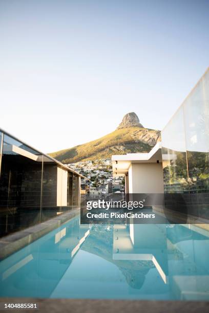 luxuriöser pool auf dem dach mit blick auf die berge in der stadt - rooftop pool stock-fotos und bilder