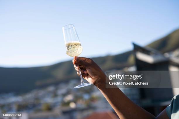 close up young african woman holding champagne flute - champagne rooftop stock pictures, royalty-free photos & images