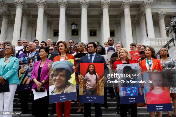 Speaker of the House Nancy Pelosi stands with fellow Democrats holding photographs of the victims of the mass shootings in Buffalo, New York and...