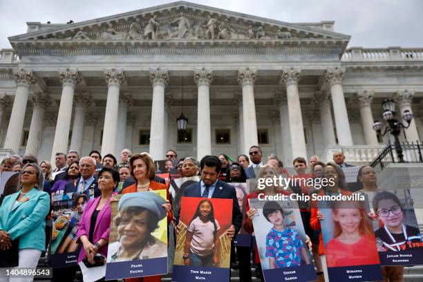 Speaker of the House Nancy Pelosi stands with fellow Democrats holding photographs of the victims of the mass shootings in Buffalo, New York and...