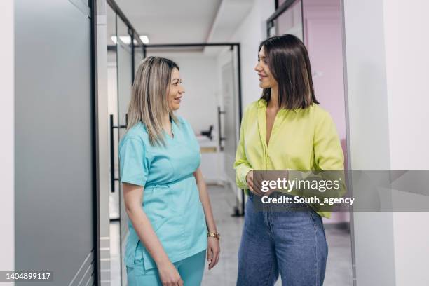 women talking at the beauty clinic - dermatologists talking to each other patient stock pictures, royalty-free photos & images