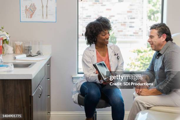 male patient is excited to see that his x-ray shows his bone is repaired - podiatrist stockfoto's en -beelden