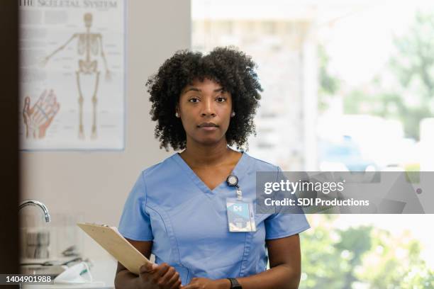 portrait serious female healthcare worker - serious stock pictures, royalty-free photos & images