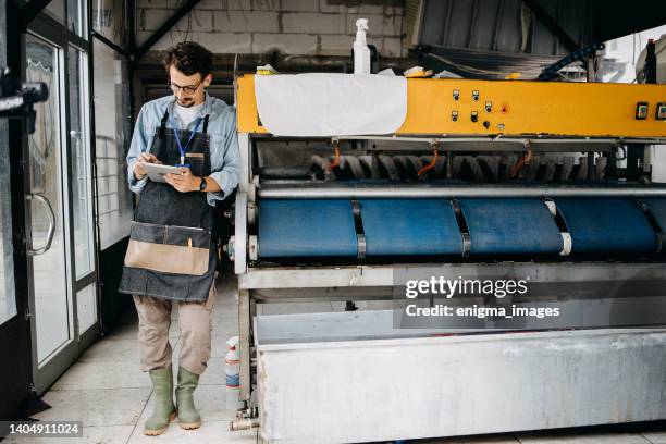 man working in a carpet laundry - dirty uniform laundry stock pictures, royalty-free photos & images
