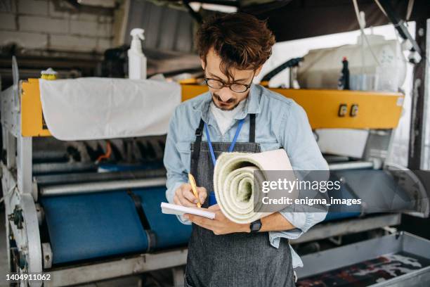 man working in a carpet laundry - wet carpet stock pictures, royalty-free photos & images