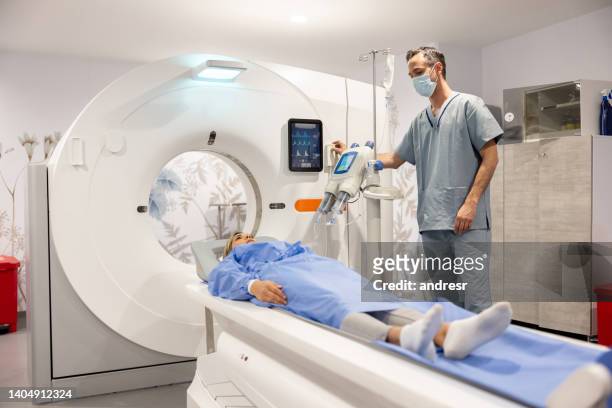 radologist getting a patient ready for an mri scan - cat scan machine stock pictures, royalty-free photos & images